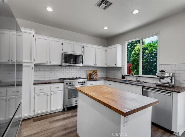 205 W Sparkleberry Ave, Orange, CA 92865 - kitchen with stainless steel appliances, wooden counters, wood finished floors, white cabinetry, and recessed lighting