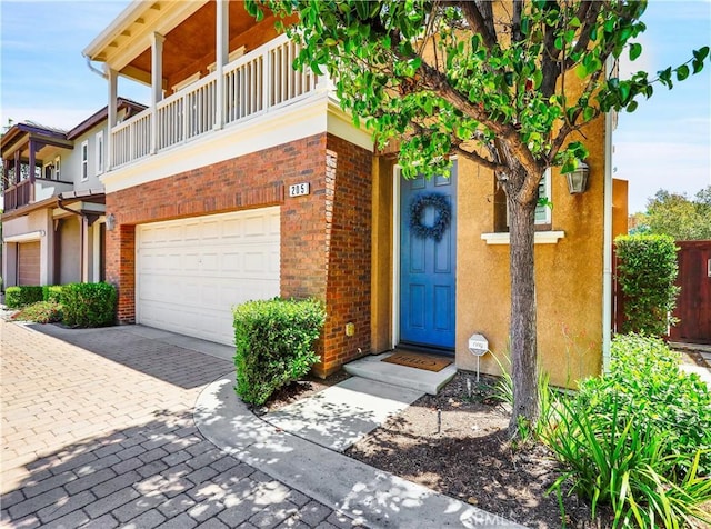 205 W Sparkleberry Ave, Orange, CA 92865 - view of front of house with a garage, brick siding, driveway, stucco siding, and a balcony