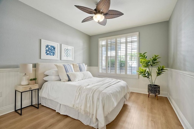 9263 Regents Rd Unit B106, La Jolla, CA 92037 - bedroom with wood finished floors, wainscoting, and ceiling fan