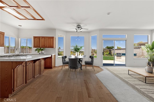 31794 Corte Rosario, Temecula, CA 92592 - kitchen with tile counters, light wood-type flooring, brown cabinets, and healthy amount of natural light