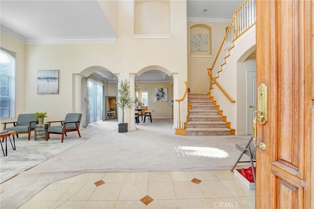 9103 Rancho Real Rd, Temple City, CA 91780 - carpeted foyer entrance featuring arched walkways, crown molding, tile patterned floors, stairway, and decorative columns