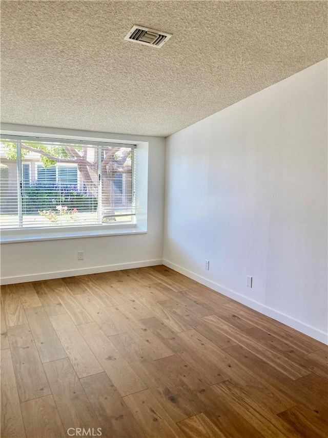1830 Sunningdale Rd Unit M14-G, Seal Beach, CA 90740 - empty room featuring hardwood / wood-style flooring, a textured ceiling, and plenty of natural light