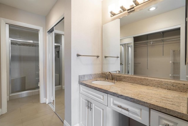 7000 Saranac St Unit 54, La Mesa, CA 91942 - bathroom featuring vanity, a walk in closet, a shower with shower door, and tile patterned flooring