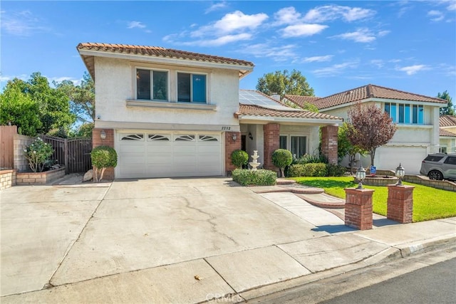 2252 Verbena Ave, Upland, CA 91784 - view of front facade featuring a tile roof, an attached garage, solar panels, and stucco siding