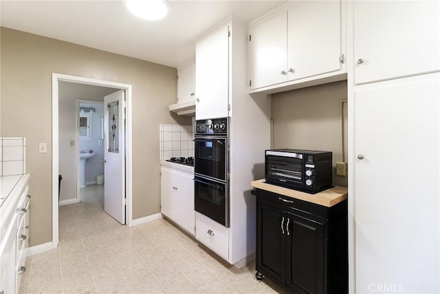1247 E Marbury St, West Covina, CA 91790 - kitchen featuring dark cabinetry, light countertops, black appliances, white cabinets, and backsplash