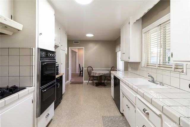 1247 E Marbury St, West Covina, CA 91790 - kitchen featuring tile counters, black appliances, white cabinetry, tasteful backsplash, and recessed lighting
