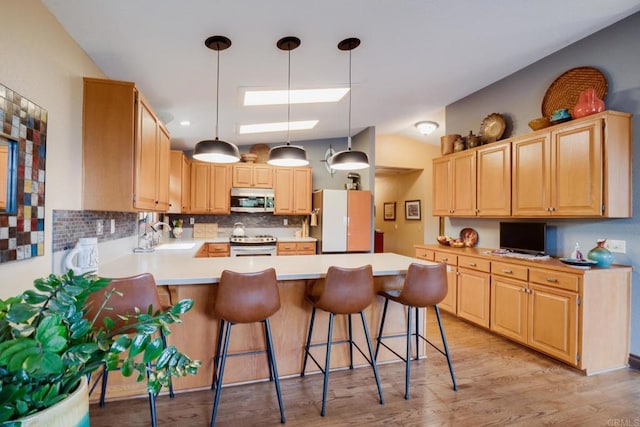 23007 Arjo Ln, Ramona, CA 92065 - kitchen featuring appliances with stainless steel finishes, a peninsula, decorative backsplash, vaulted ceiling, and a breakfast bar