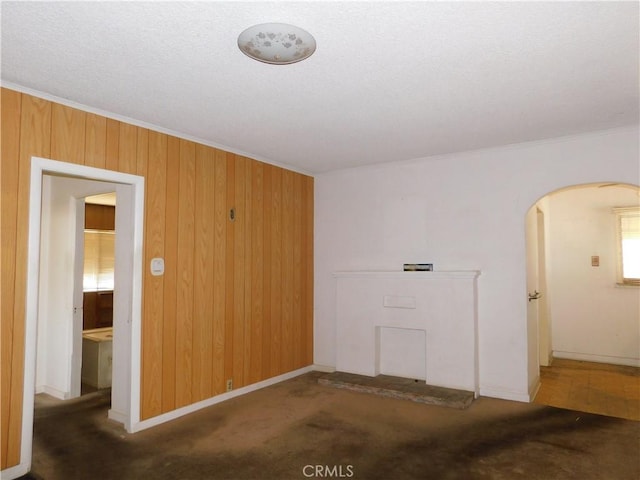 10852 Otsego St, North Hollywood, CA 91601 - unfurnished room featuring arched walkways, ornamental molding, wood walls, and carpet flooring