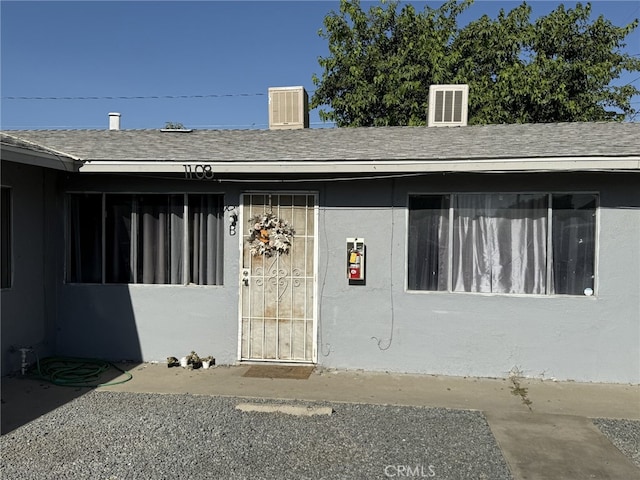 1108 N Rinaldi St, Visalia, CA 93291 - doorway to property featuring a shingled roof and stucco siding