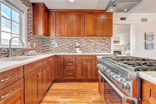 6232 Richmond Ave, Garden Grove, CA 92845 - kitchen featuring stainless steel range with gas cooktop, light countertops, range hood, and brown cabinetry