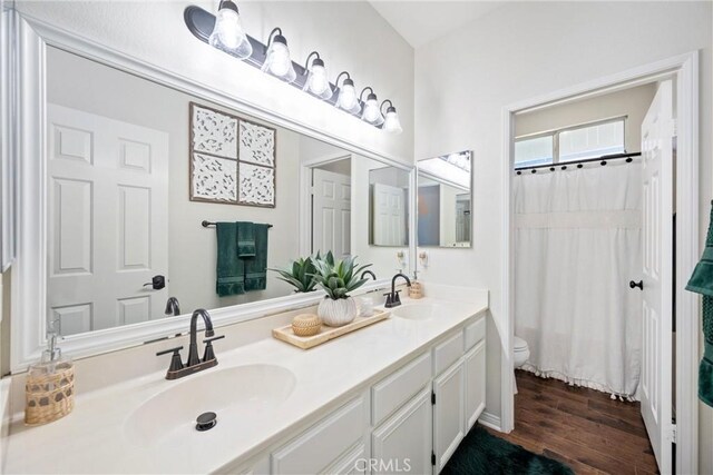 19205 Sterling Hill Ln, Perris, CA 92570 - full bathroom with double vanity, wood finished floors, and a shower with shower curtain