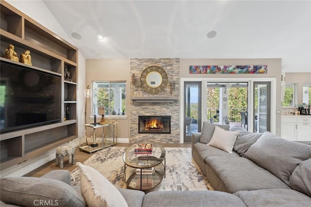 24311 Sylvan Glen Rd, Calabasas, CA 91302 - living area with lofted ceiling, a stone fireplace, plenty of natural light, and wood finished floors