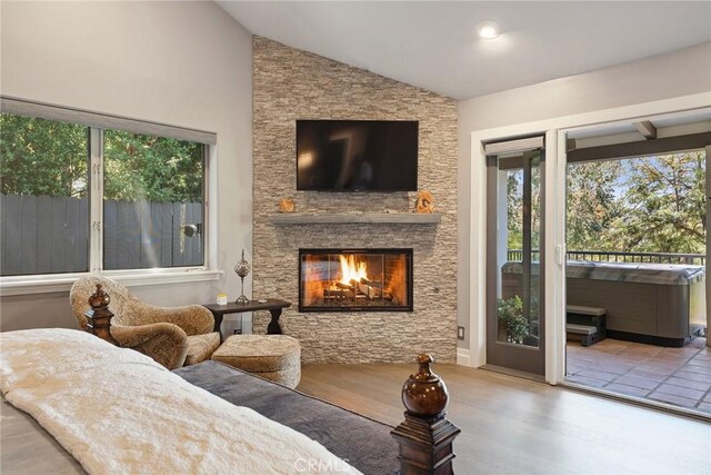 24311 Sylvan Glen Rd, Calabasas, CA 91302 - living room with healthy amount of natural light, vaulted ceiling, a stone fireplace, and wood finished floors