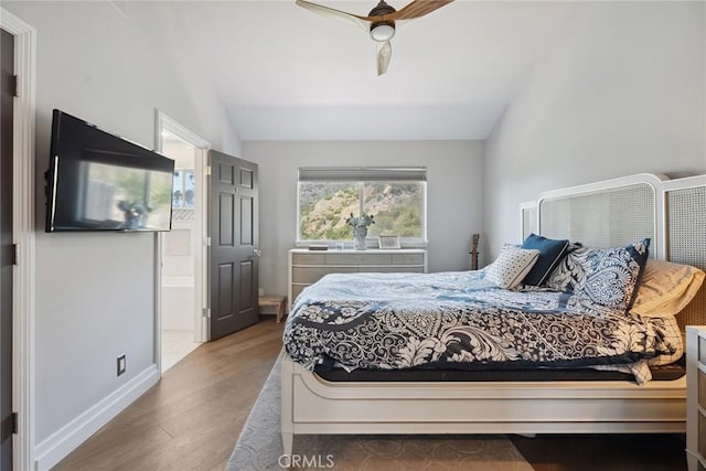 24311 Sylvan Glen Rd, Calabasas, CA 91302 - bedroom featuring vaulted ceiling, wood finished floors, connected bathroom, and ceiling fan