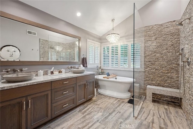 24311 Sylvan Glen Rd, Calabasas, CA 91302 - full bath with a walk in shower, vaulted ceiling, double vanity, a freestanding bath, and a chandelier
