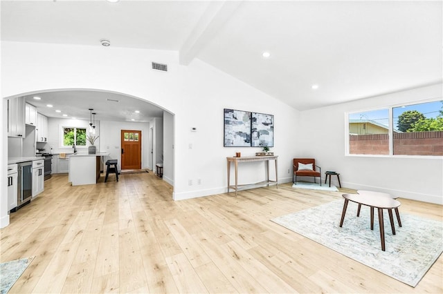 6816 E Driscoll St, Long Beach, CA 90815 - living area with arched walkways, light wood finished floors, wine cooler, and recessed lighting
