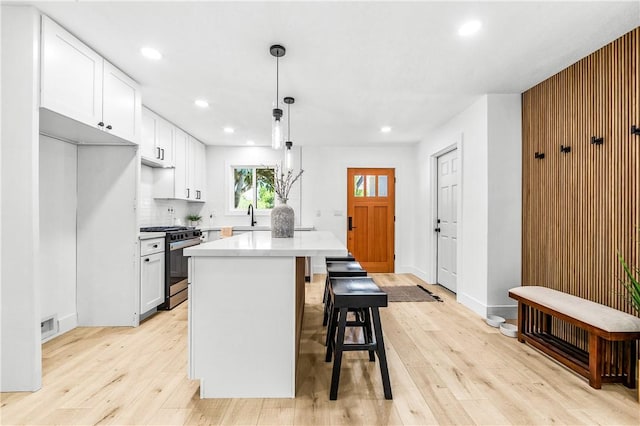 6816 E Driscoll St, Long Beach, CA 90815 - kitchen with gas stove, light wood-style floors, a kitchen island, recessed lighting, and light countertops