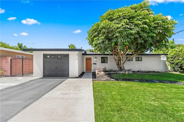 6816 E Driscoll St, Long Beach, CA 90815 - view of front of home with stucco siding, a garage, concrete driveway, and a front lawn