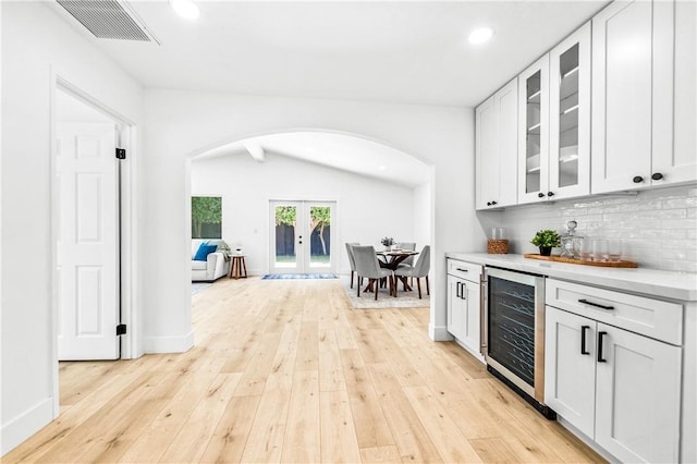 6816 E Driscoll St, Long Beach, CA 90815 - indoor dry bar with arched walkways, wine cooler, light wood-style floors, tasteful backsplash, and recessed lighting