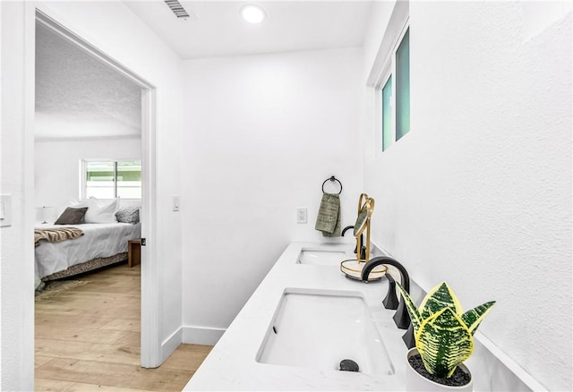 6816 E Driscoll St, Long Beach, CA 90815 - ensuite bathroom featuring double vanity, wood finished floors, and recessed lighting