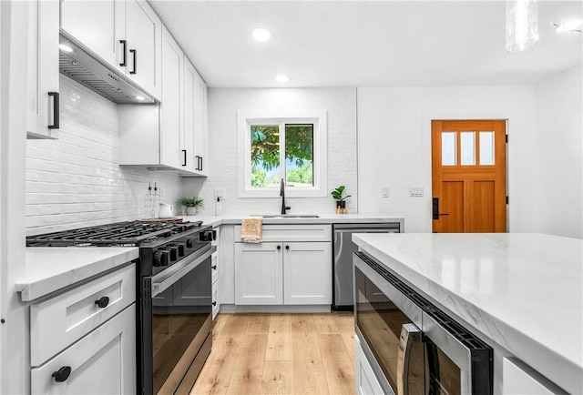 6816 E Driscoll St, Long Beach, CA 90815 - kitchen featuring stainless steel appliances, exhaust hood, recessed lighting, backsplash, and light wood-style flooring