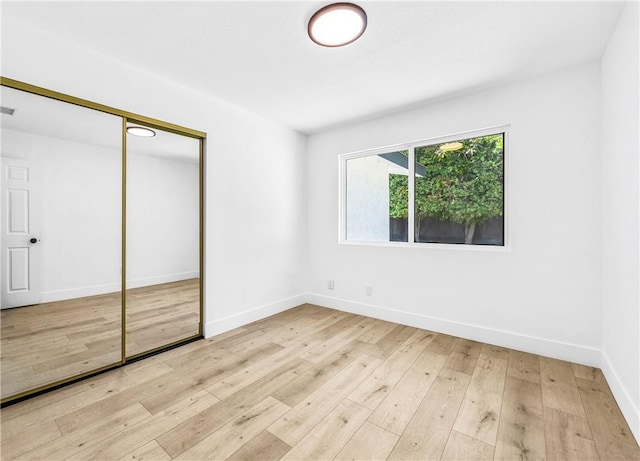 6816 E Driscoll St, Long Beach, CA 90815 - unfurnished bedroom with light wood finished floors and a closet