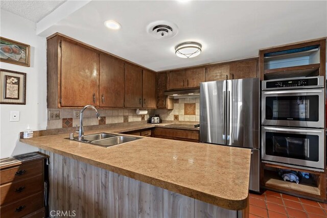 57795 El Dorado Dr, Yucca Valley, CA 92284 - kitchen featuring stainless steel appliances, a peninsula, tasteful backsplash, tile patterned floors, and recessed lighting