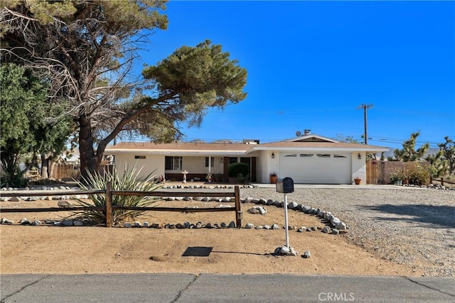 57795 El Dorado Dr, Yucca Valley, CA 92284 - ranch-style house with a fenced front yard, an attached garage, and gravel driveway