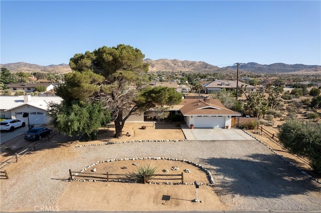57795 El Dorado Dr, Yucca Valley, CA 92284 - view of front of home with a mountain view, concrete driveway, a residential view, and a garage