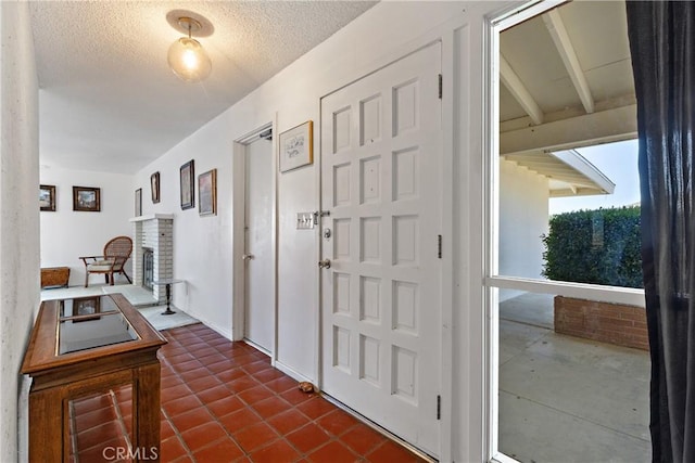 57795 El Dorado Dr, Yucca Valley, CA 92284 - foyer entrance featuring a brick fireplace and a textured ceiling