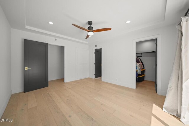 9518 Forbes Ave, Northridge, CA 91343 - unfurnished bedroom featuring a tray ceiling, light wood-type flooring, a walk in closet, recessed lighting, and a closet