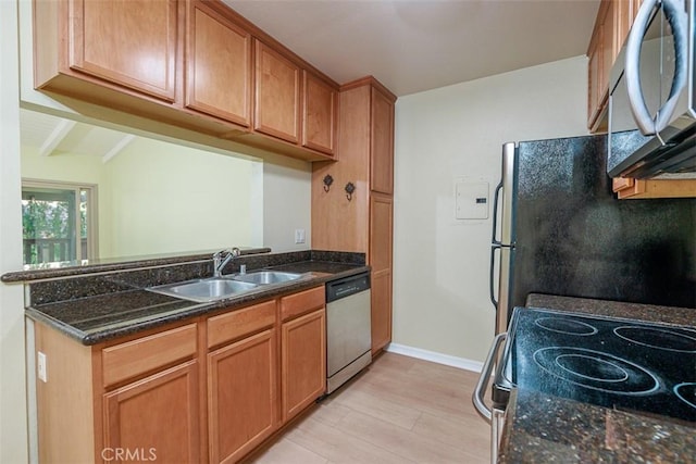 1345 Cabrillo Park Dr Unit A06, Santa Ana, CA 92701 - kitchen featuring appliances with stainless steel finishes, light wood-style floors, a peninsula, dark stone countertops, and brown cabinetry