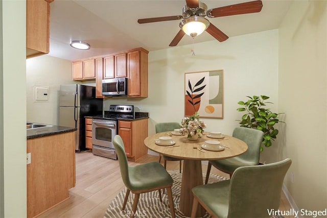 1345 Cabrillo Park Dr Unit A06, Santa Ana, CA 92701 - kitchen with appliances with stainless steel finishes, light wood-style flooring, dark countertops, and a ceiling fan
