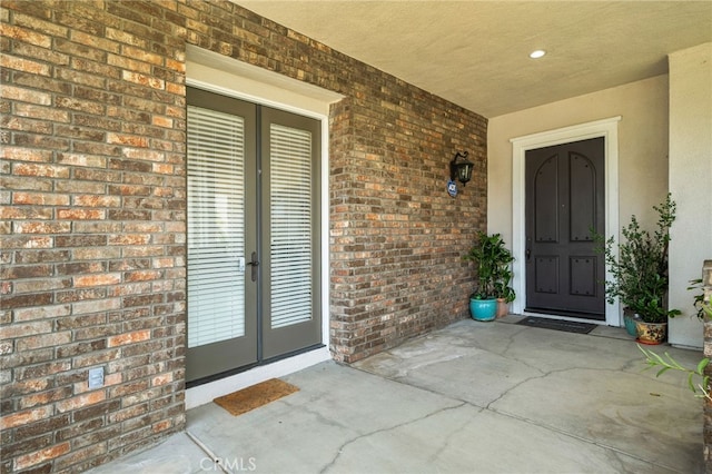 13812 Breeders Cup Dr, Rancho Cucamonga, CA 91739 - view of exterior entry featuring french doors, stucco siding, and brick siding