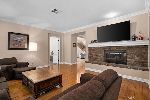 13812 Breeders Cup Dr, Rancho Cucamonga, CA 91739 - living area featuring hardwood / wood-style floors, stairs, a brick fireplace, and ornamental molding