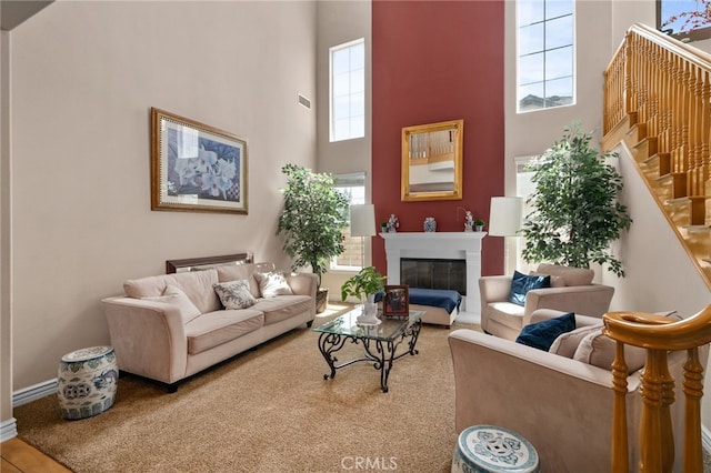 13812 Breeders Cup Dr, Rancho Cucamonga, CA 91739 - living area featuring a towering ceiling, stairs, and a fireplace with flush hearth