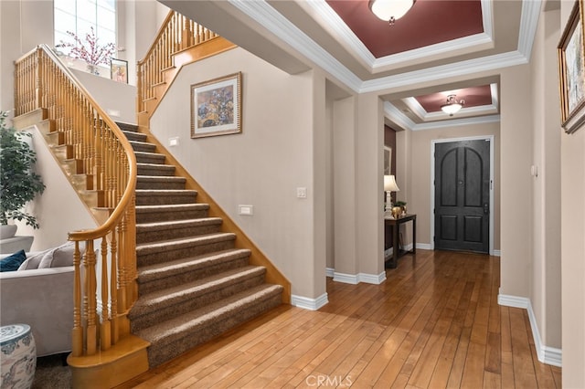 13812 Breeders Cup Dr, Rancho Cucamonga, CA 91739 - entryway with ornamental molding, a raised ceiling, stairway, and wood-type flooring