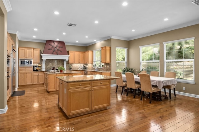 13812 Breeders Cup Dr, Rancho Cucamonga, CA 91739 - kitchen featuring a center island, stainless steel microwave, custom exhaust hood, decorative backsplash, and recessed lighting