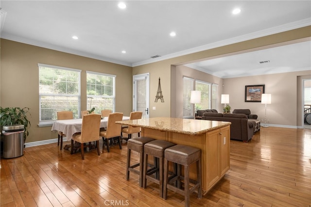 13812 Breeders Cup Dr, Rancho Cucamonga, CA 91739 - kitchen with light wood-type flooring, a center island, plenty of natural light, ornamental molding, and recessed lighting