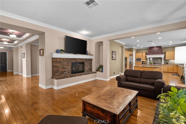 13812 Breeders Cup Dr, Rancho Cucamonga, CA 91739 - living room with a glass covered fireplace, light wood-type flooring, crown molding, and recessed lighting