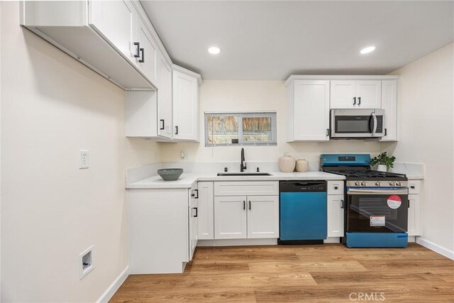 326 Water St, Bakersfield, CA 93305 - kitchen with appliances with stainless steel finishes, light wood-style floors, light countertops, white cabinetry, and recessed lighting