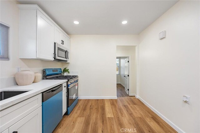 326 Water St, Bakersfield, CA 93305 - kitchen with appliances with stainless steel finishes, light wood-style floors, white cabinets, light countertops, and recessed lighting