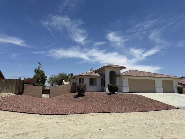 31100 Desert Palm Dr, Thousand Palms, CA 92276 - mediterranean / spanish house featuring a tiled roof, an attached garage, concrete driveway, and stucco siding