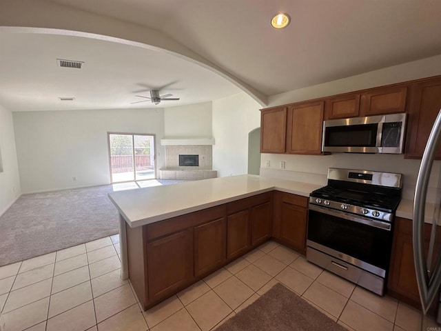 31100 Desert Palm Dr, Thousand Palms, CA 92276 - kitchen featuring stainless steel appliances, vaulted ceiling, open floor plan, a ceiling fan, and a tile fireplace