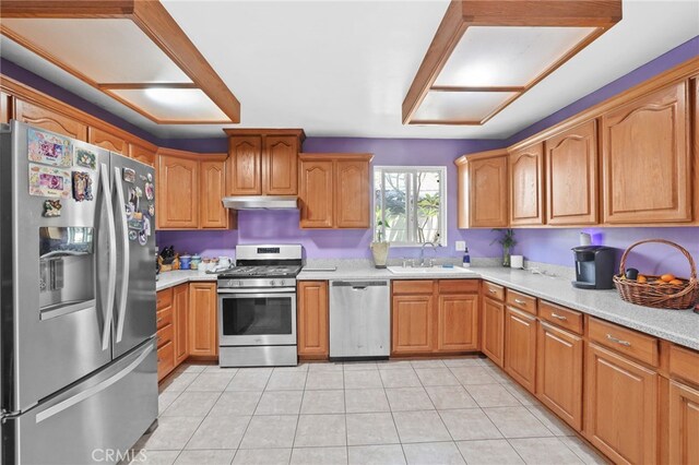 1002 N Iroquois Ave, Anaheim, CA 92801 - kitchen with stainless steel appliances, under cabinet range hood, light countertops, light tile patterned floors, and brown cabinets
