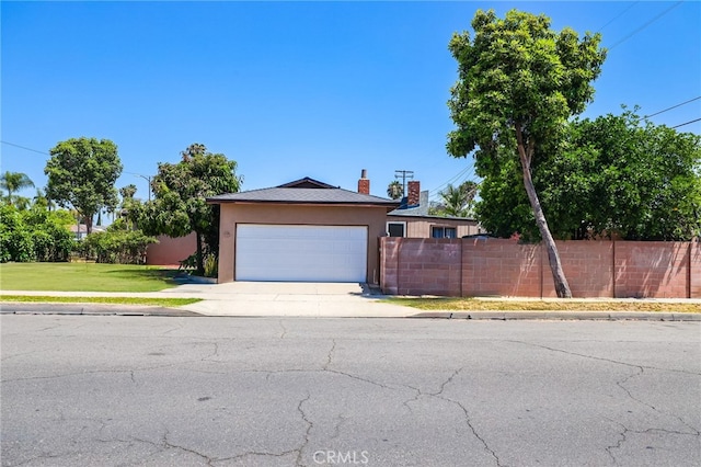 1002 N Iroquois Ave, Anaheim, CA 92801 - view of front facade featuring concrete driveway, stucco siding, an attached garage, and a chimney