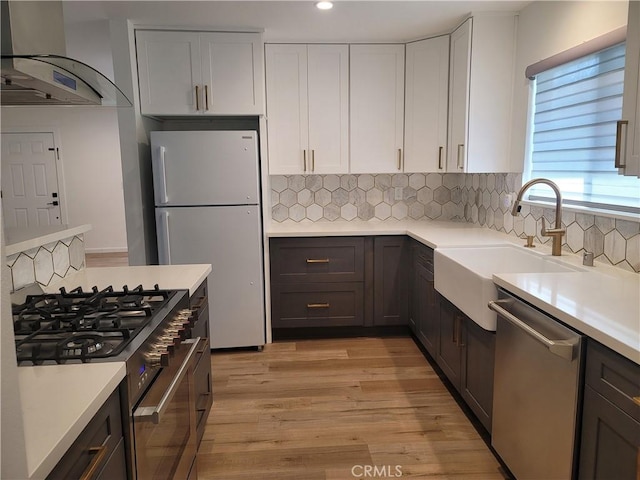 6091 Larchwood Dr, Huntington Beach, CA 92647 - kitchen with stainless steel appliances, wall chimney range hood, light countertops, and recessed lighting