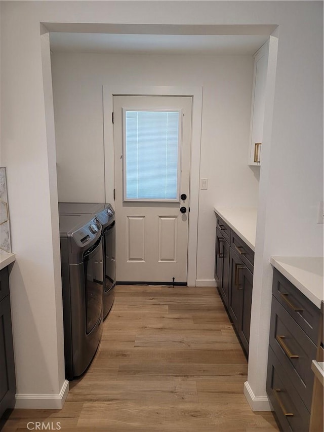 6091 Larchwood Dr, Huntington Beach, CA 92647 - washroom featuring cabinet space, washer and clothes dryer, and light wood-style flooring