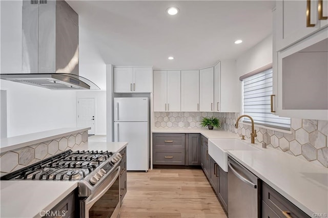6091 Larchwood Dr, Huntington Beach, CA 92647 - kitchen with appliances with stainless steel finishes, extractor fan, light countertops, light wood finished floors, and recessed lighting
