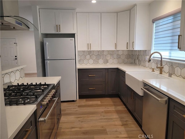 6091 Larchwood Dr, Huntington Beach, CA 92647 - kitchen featuring stainless steel appliances, wall chimney range hood, light countertops, and recessed lighting